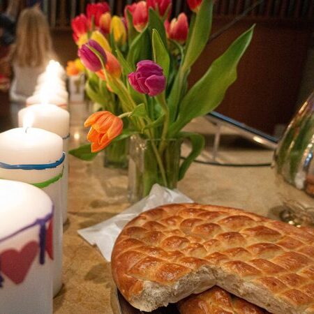 Abendmahltisch mit Kerzen, Blumen und Brot